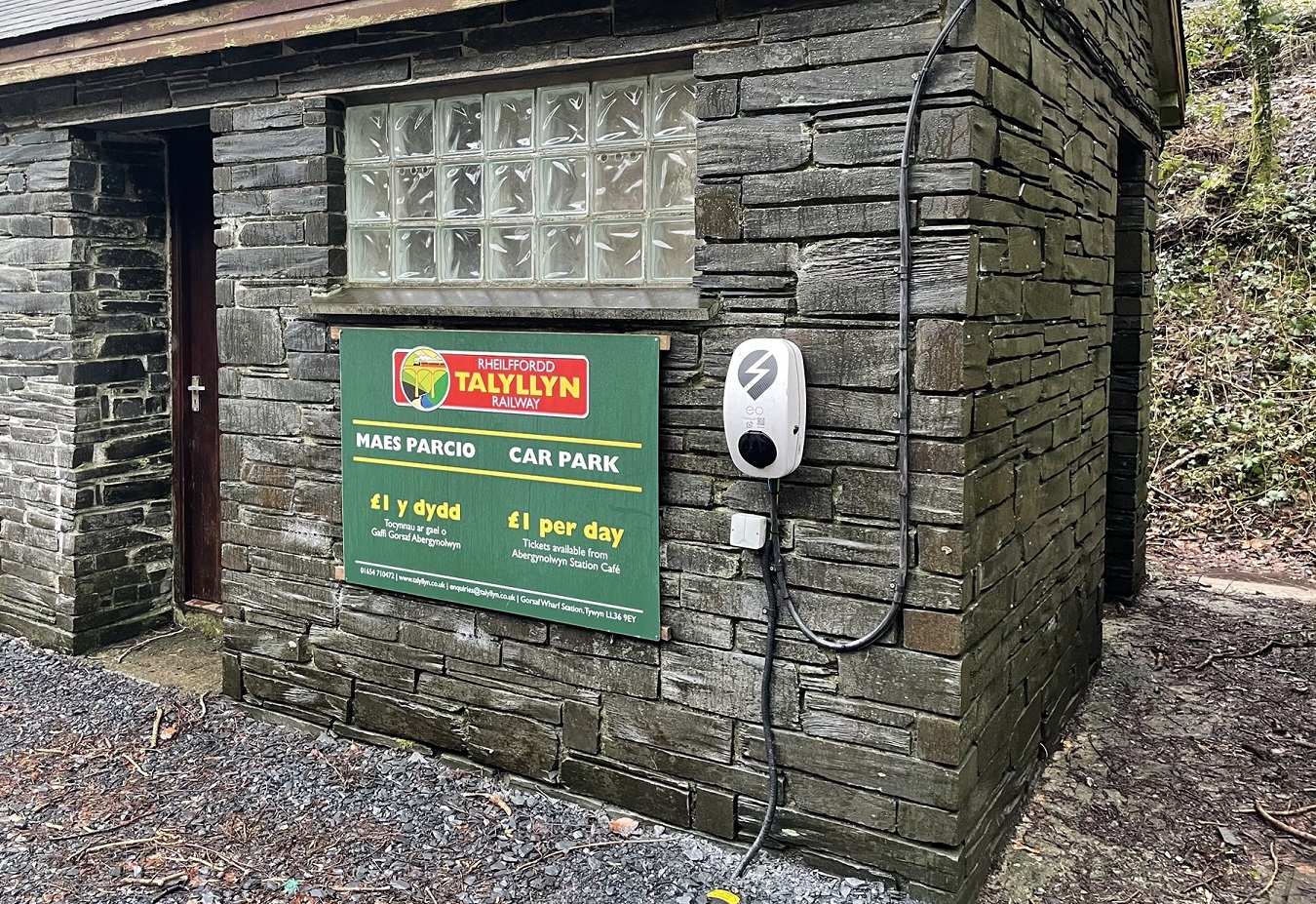 A car charging station on a building wall.