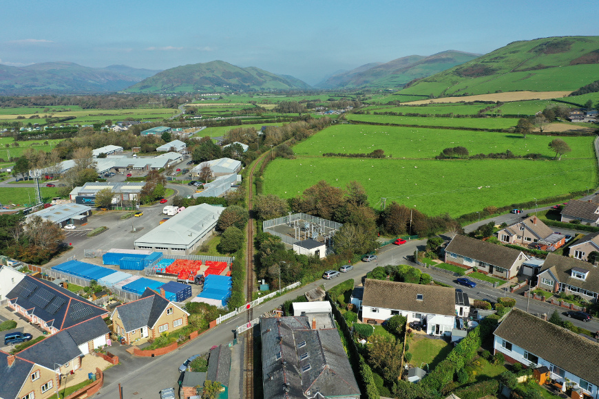 An aerial shot looking over the hills up the line past Pendre level crossing.
