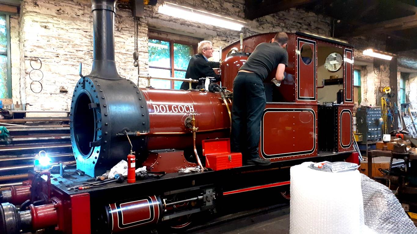 A steam loco with two men working on it.