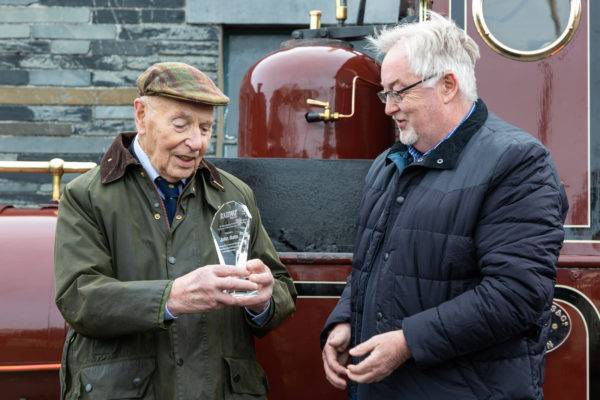 John Bate is presented with the ‘Railway Magazine Annual Award for Services to Railway Preservation’ by the editor of Railway Magazine, Chris Milner (right), at a ceremony held in front of locomotive No.2 Dolgoch at Tywyn Pendre.