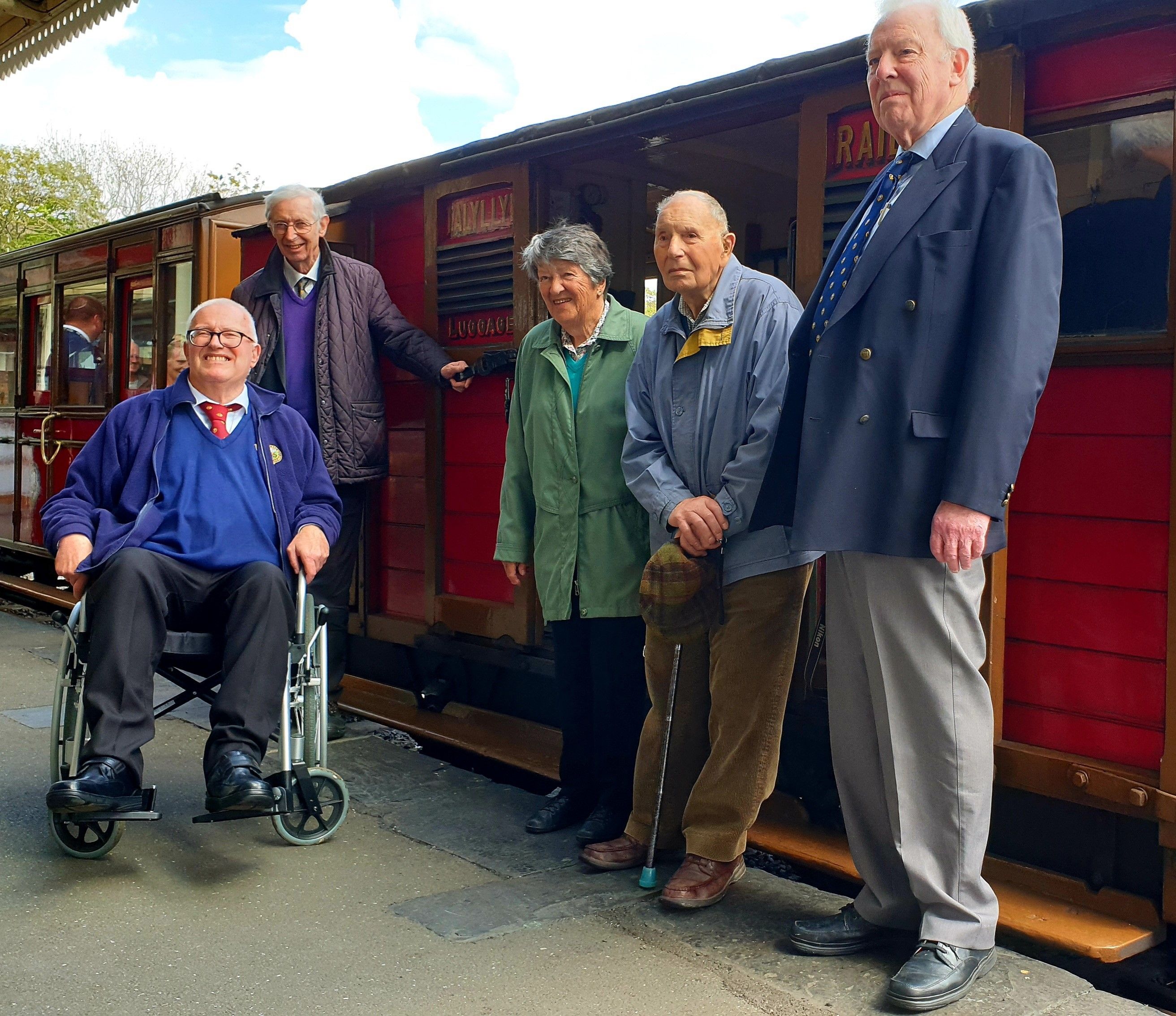 Five people in front of a vintage Guard's Van.