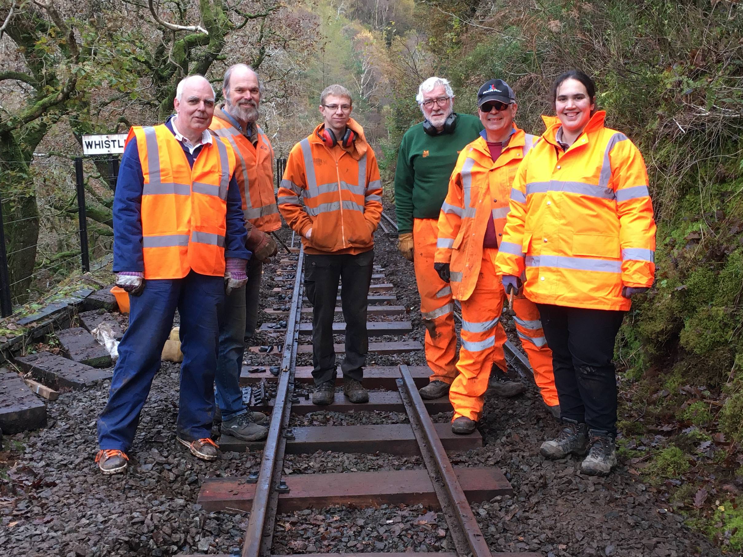 A group of people in hi-vis clothing on a length of track.