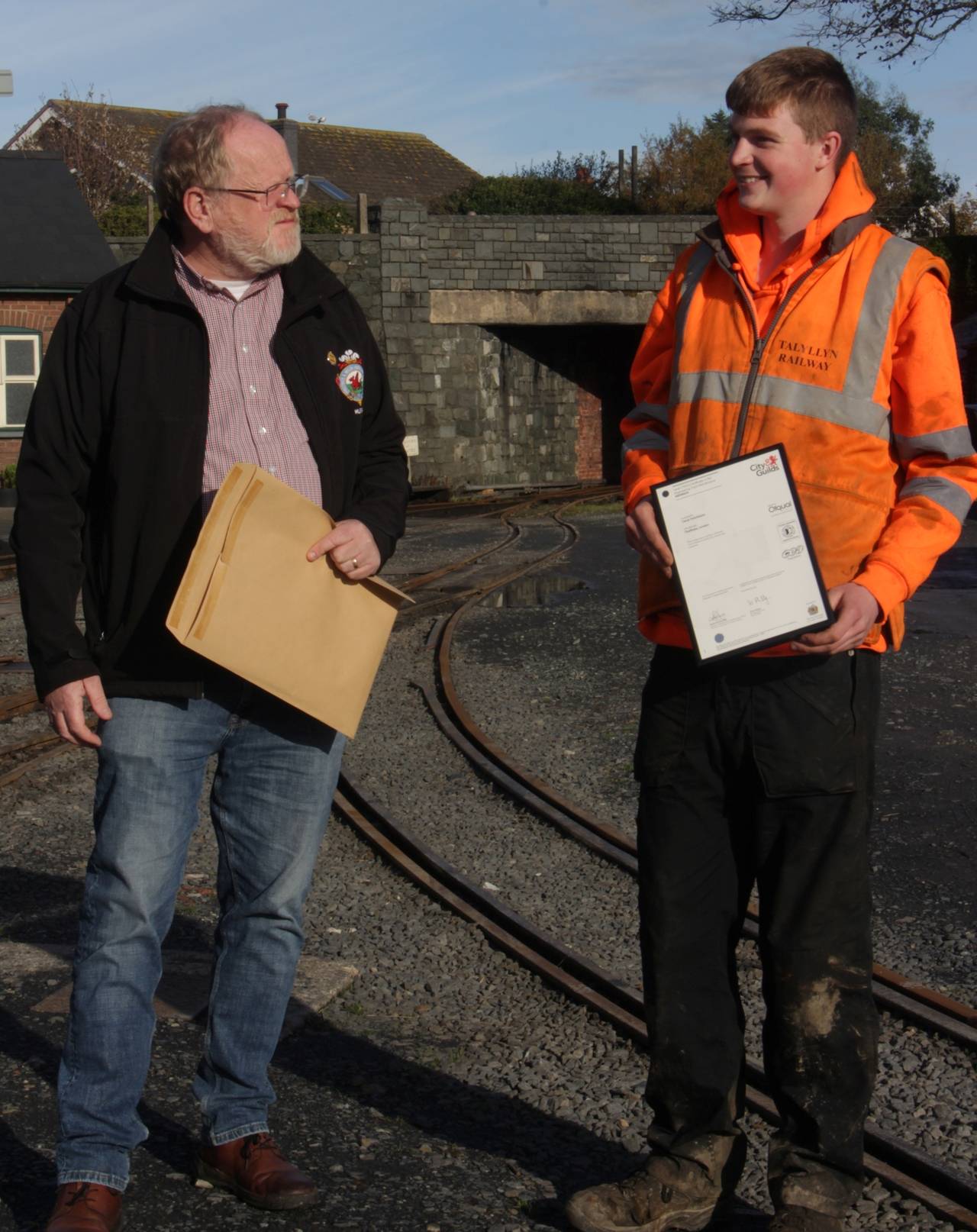 Two men with certificates.