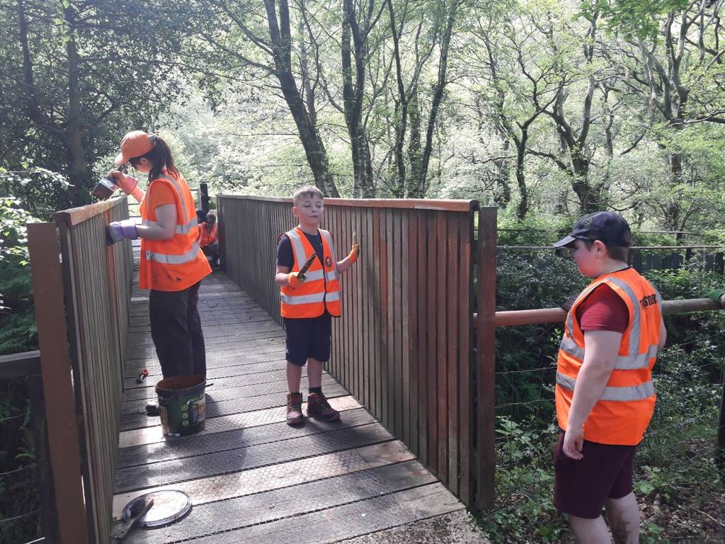 Children painting footbridge railings.