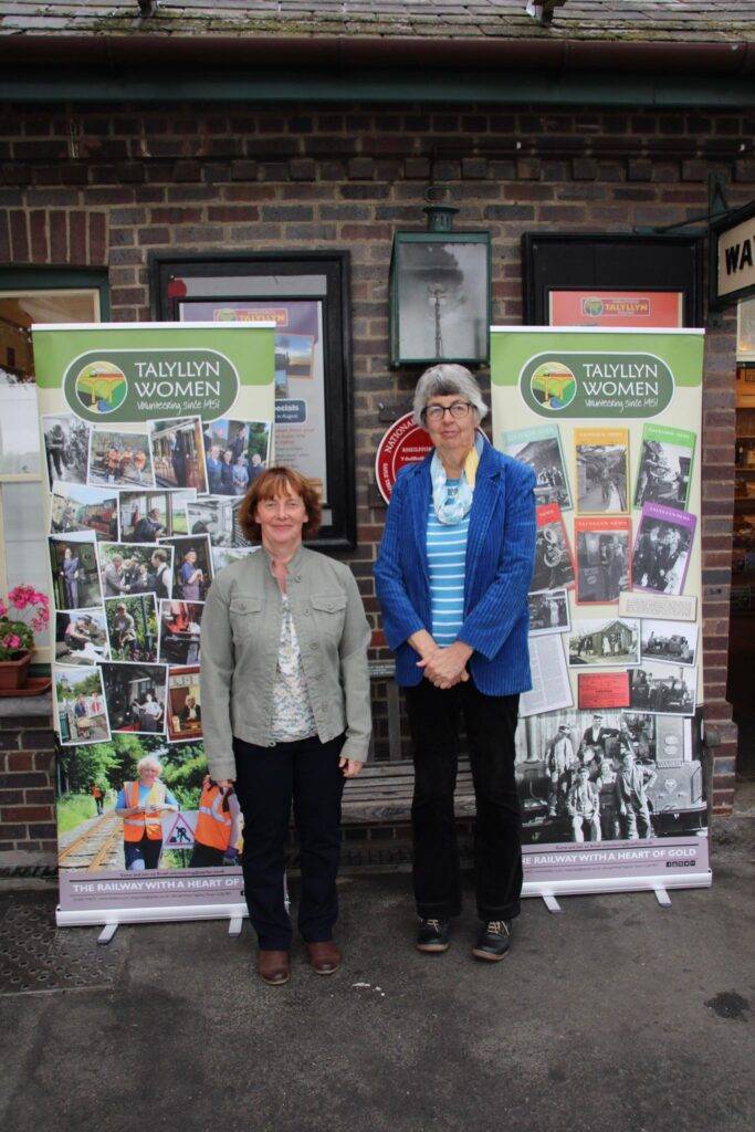 Two women stood in front of pull up banners.