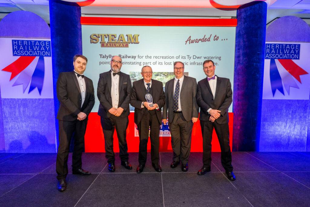 A group of people on a stage receiving an award.