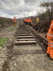 A group of people removing rails from a railway line.