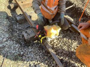 A person using a rail mounted drill on a rail.